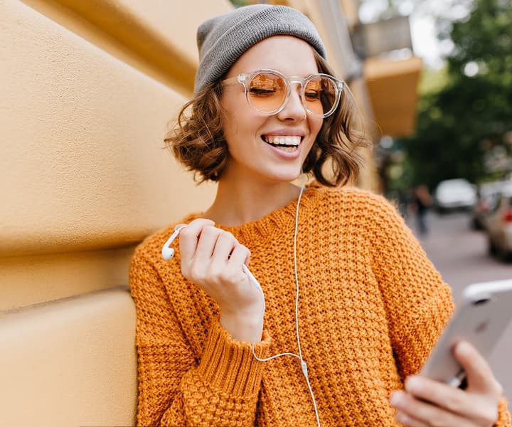 Woman in headphones attending an online course on her phone